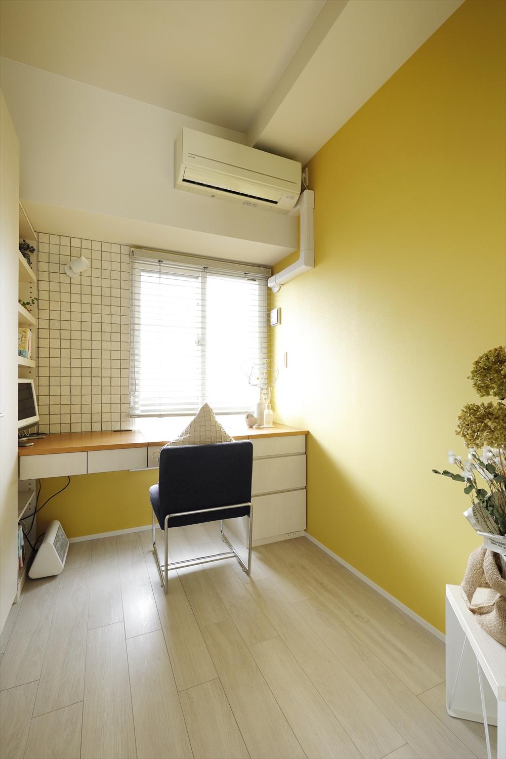 書斎スペース。以前造作したカウンターデスクを再利用しつつ、内装を一新。黄色のアクセントクロスやタイルで明るい雰囲気に。