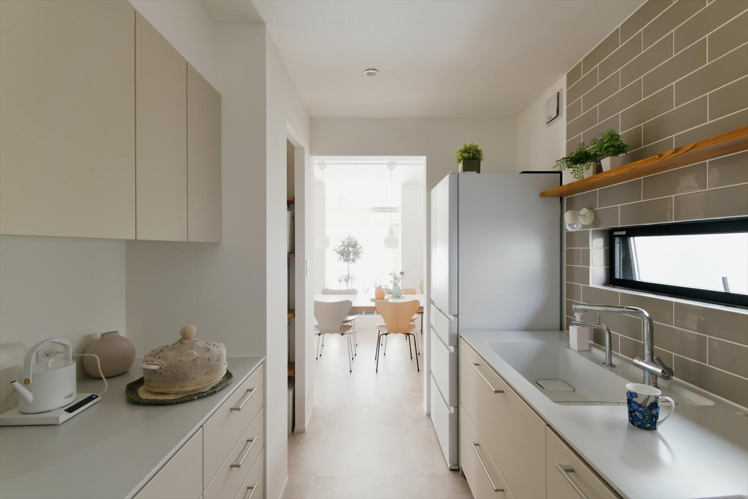 キッチンは設備を変えて、そのまま廊下へ抜けられるパントリーを設けた。キッチン全体の収納力が上がり、いつでもスッキリを保てるキッチンに