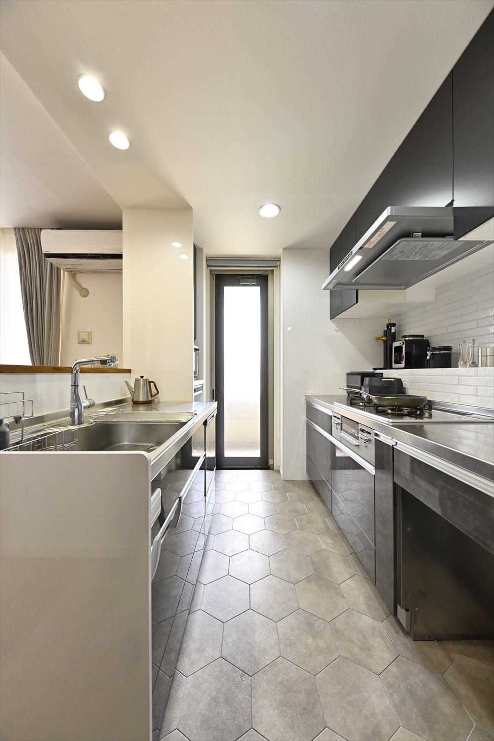 キッチンには素材感の違うヘキサゴン柄のタイルを。キッチンは壁付けから壁付け＆対面の二型キッチンに交換。限られた空間でも作業スペースを広く取れる配置に