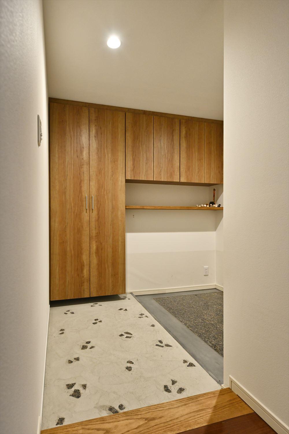 玄関土間はベビーカーや自転車を置けるよう、スペースを拡大。既存の御影石は再利用し、一部取り外した石を砕いて広げた土間部分に埋め込んだ。段差は出るが、デザイン的な違和感を無くしている