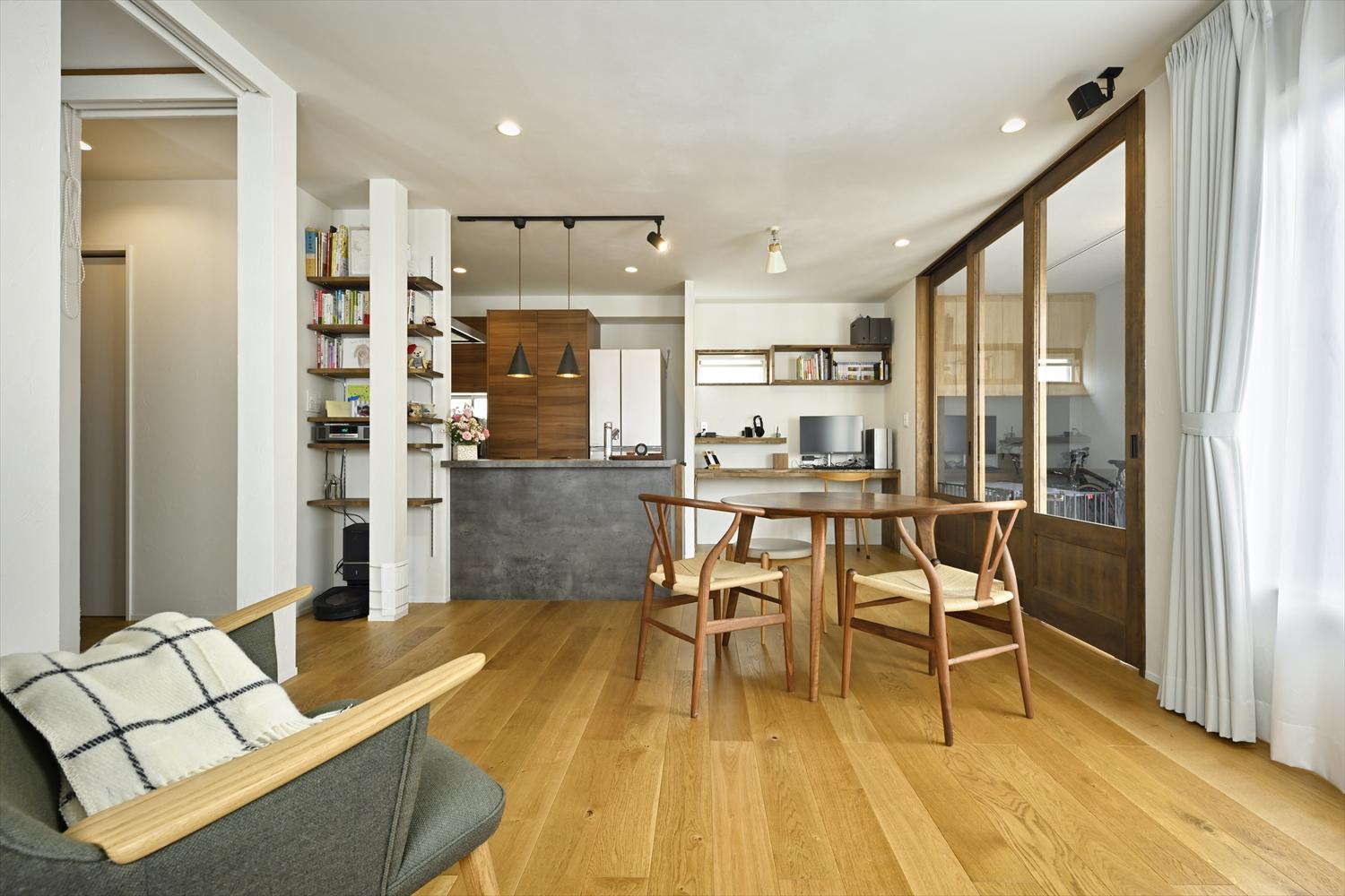 廊下側の壁を一部取り除き、廊下をリビング内に取り込んで解放感がアップしたリビング・ダイニング。奥のキッチンも対面式に。