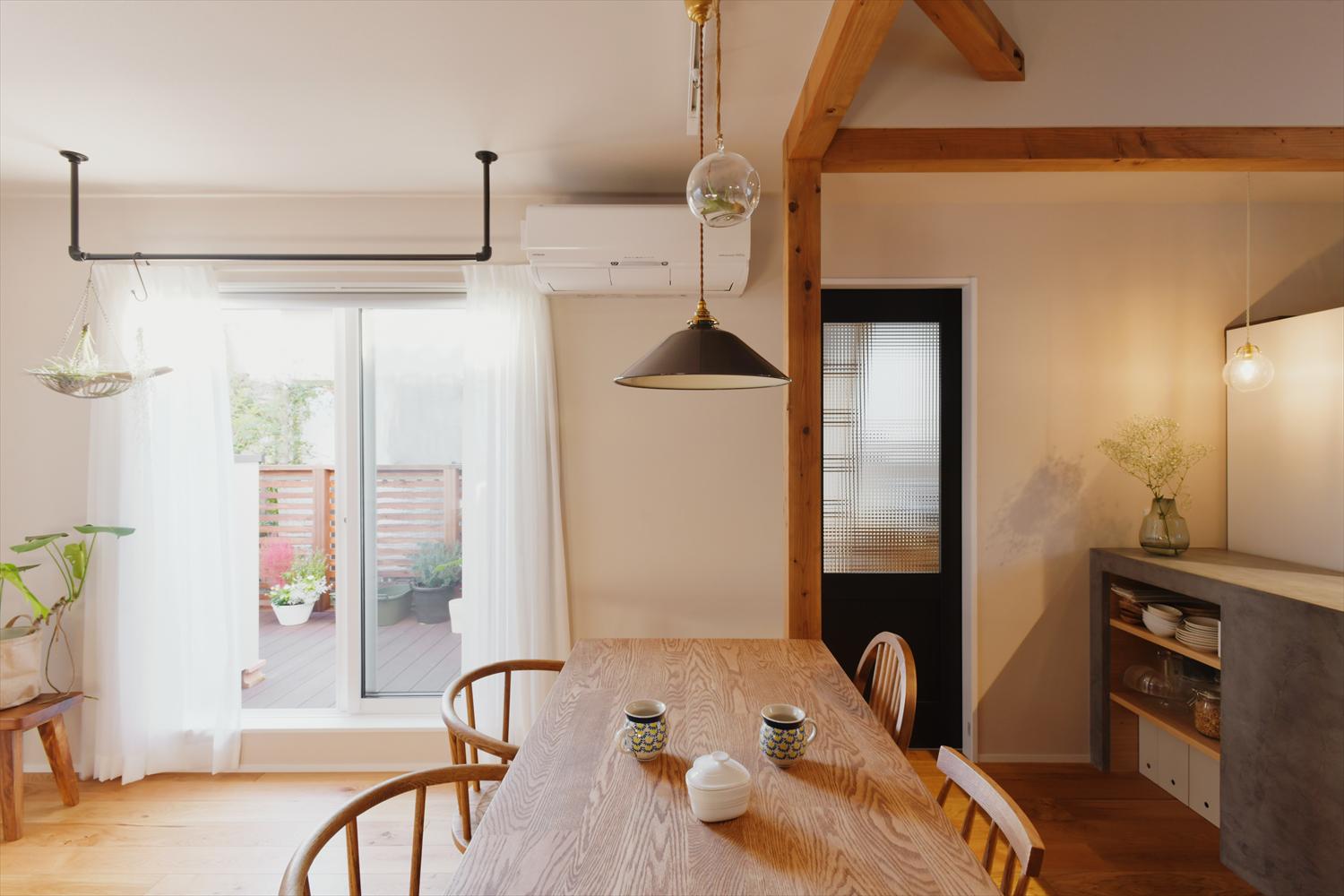 サッシは全て断熱性の高いものに交換。床暖房も入れて、1年を通して快適な空間になったLDK。
バルコニーと繋がる窓際には室内干しに使えるアイアンバーを設置。サンルームを撤去して、バルコニーにしたことで、リビングに直接陽の光が届くようになった。