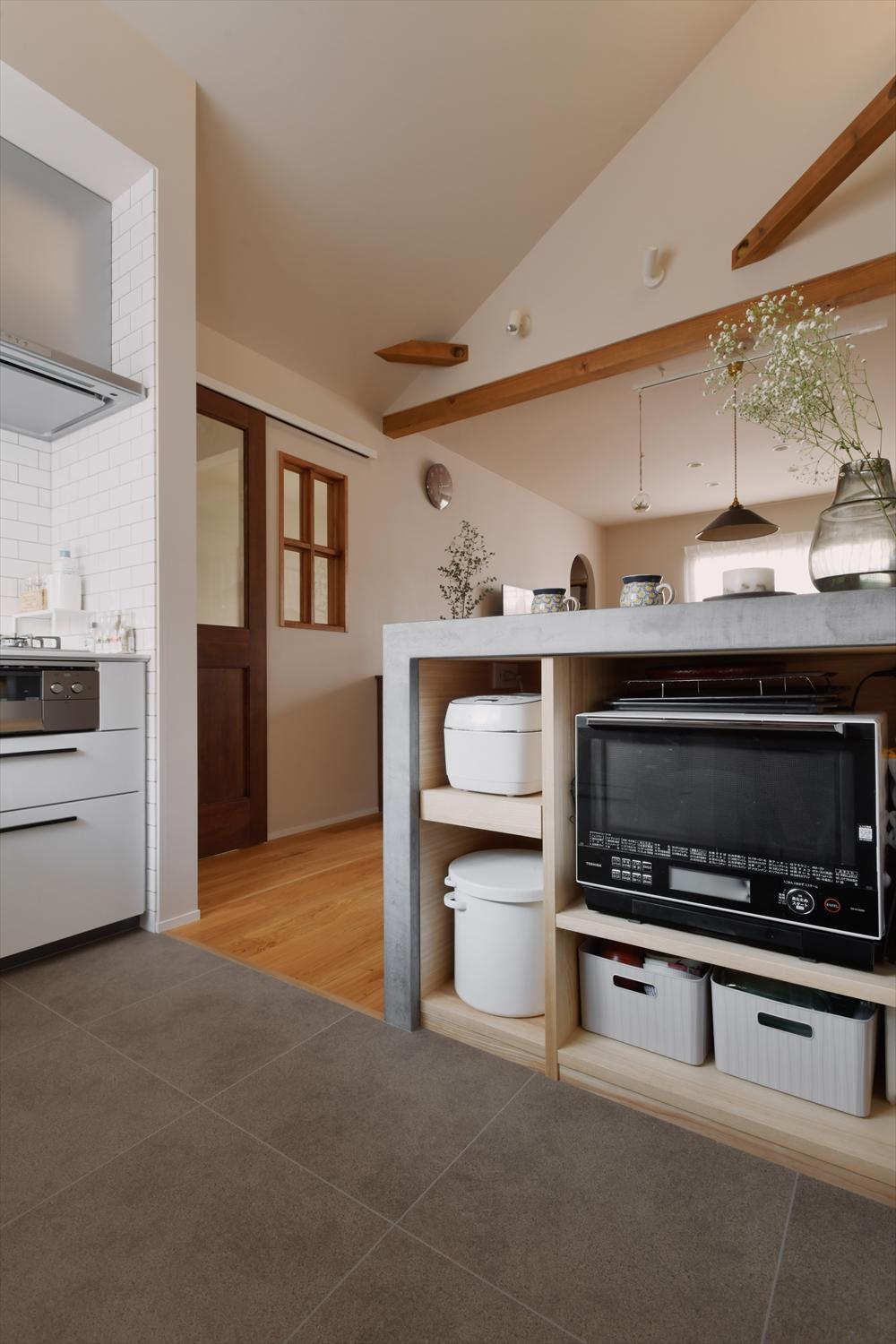 家族で料理したい！というご要望に、L型の壁付けキッチン＋広々作業カウンターで応えた。作業台のキッチン側は収納にもなっている。キッチン横にパントリーも作り、いつでもスッキリ片付くキッチンに。