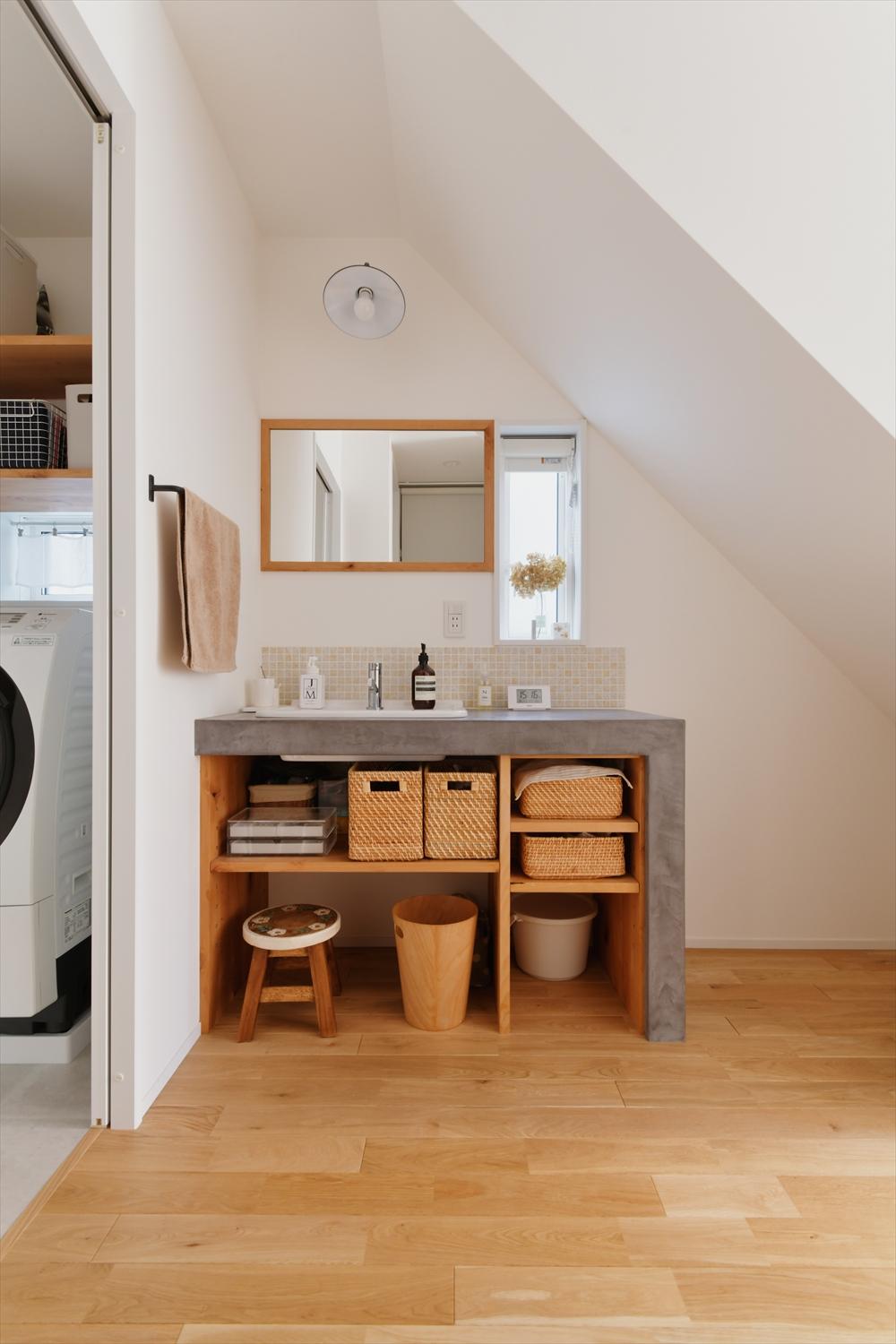 洗面は脱衣所から出してオープンな空間に。帰宅後の手洗いや来客時にも案内しやすい。シンプルなデザインの造作洗面台は、キッチンの作業カウンターと同じくモールテックスで仕上げた