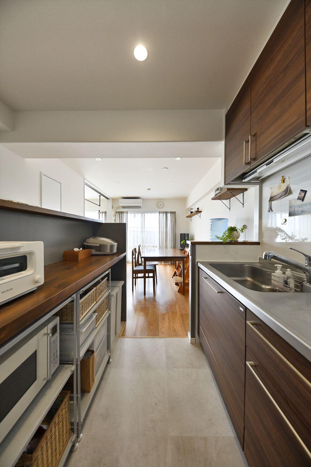 キッチンは設備はそのまま、壁を取り払っただけでオープンで明るい空間に。背面には作業台兼収納カウンターを配置。