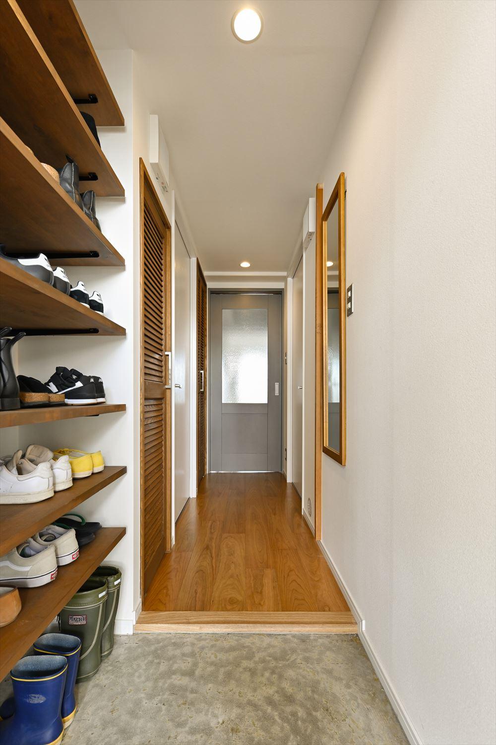 玄関にはオープンな収納を設けた。収納量もたっぷり！廊下右手鏡の奥にある柱は、元々和室の引き戸枠で、お子さんたちの背くらべの柱。これからもお子さんたちの成長を刻んでいく