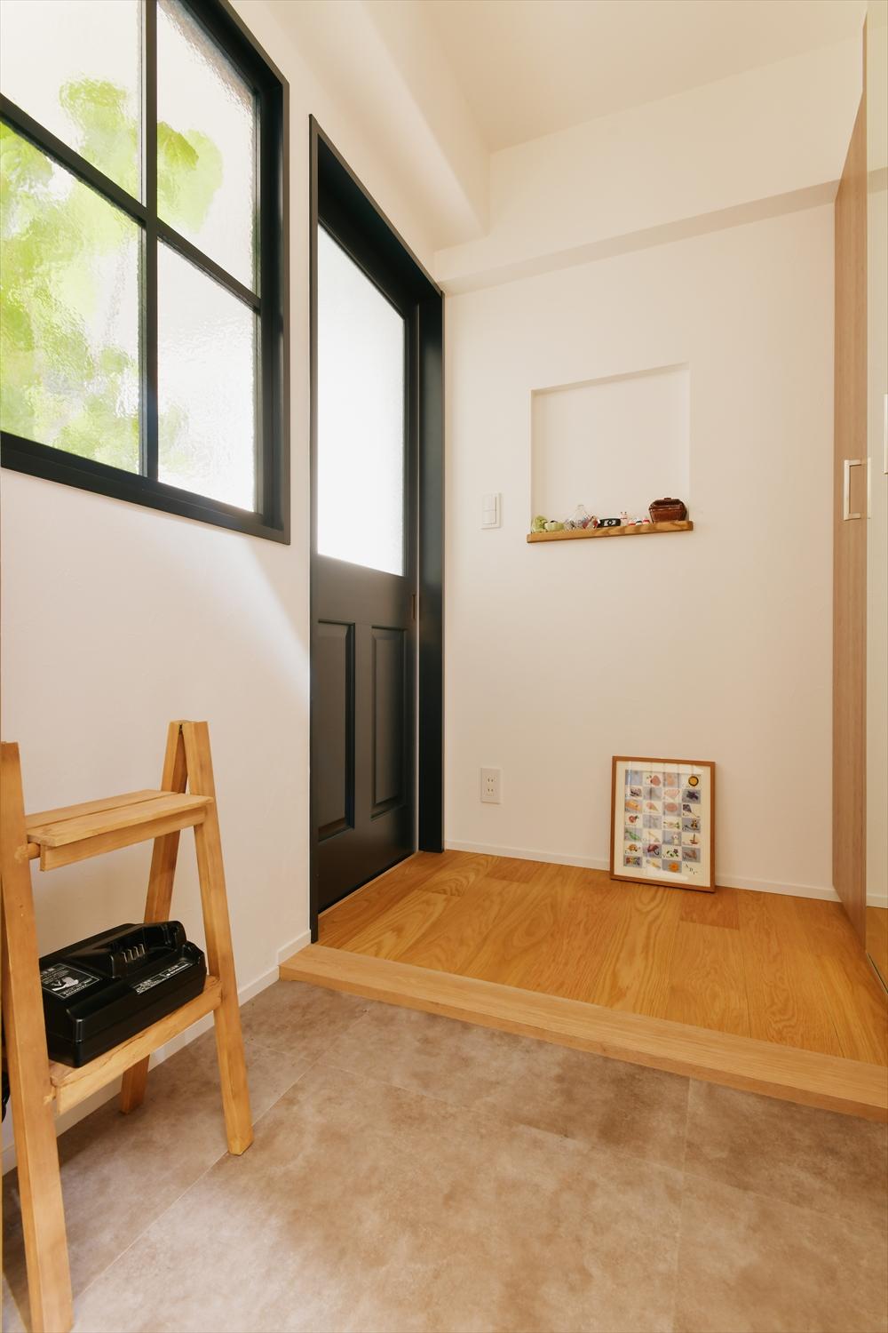 玄関は框の位置を変えてより使い勝手良く。室内の冷暖房効率を考えて、建具を設置。建具の大きなガラスと室内窓で明るい玄関に。