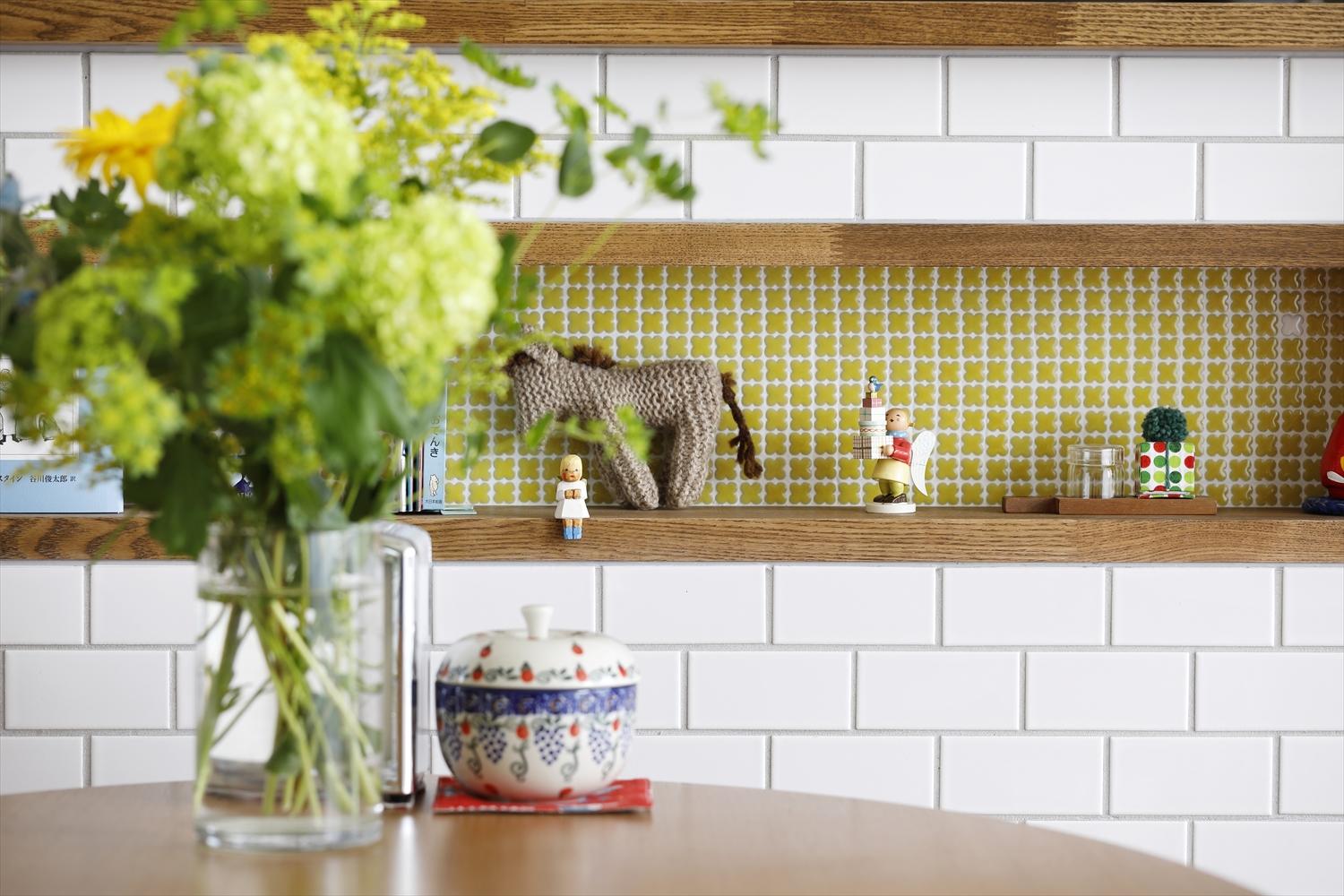 キッチンカウンターにつくったニッチには、花をモチーフにしたタイルをあしらった。1つだけ色を変えて可愛らしい雰囲気に。