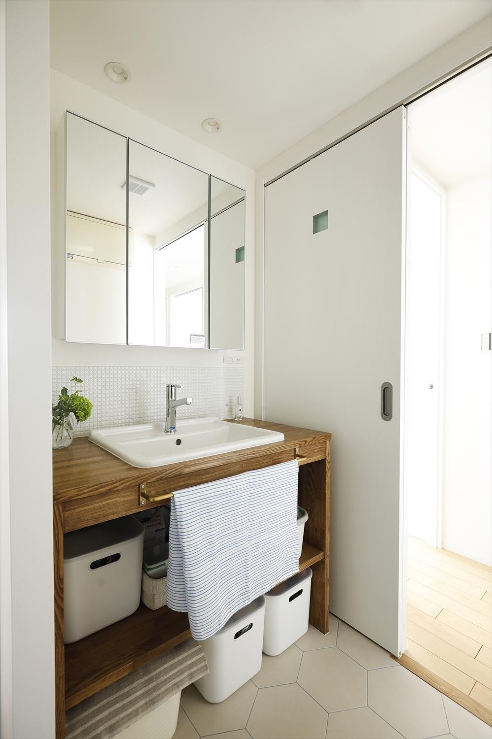 洗面台を廊下側に移動し、洗面をキッチン側に。ちょっとした変化で家事効率がぐっとアップ。造作洗面の立ち上がりに貼ったタイルはキッチンカウンターのニッチと同じシリーズの色違い。