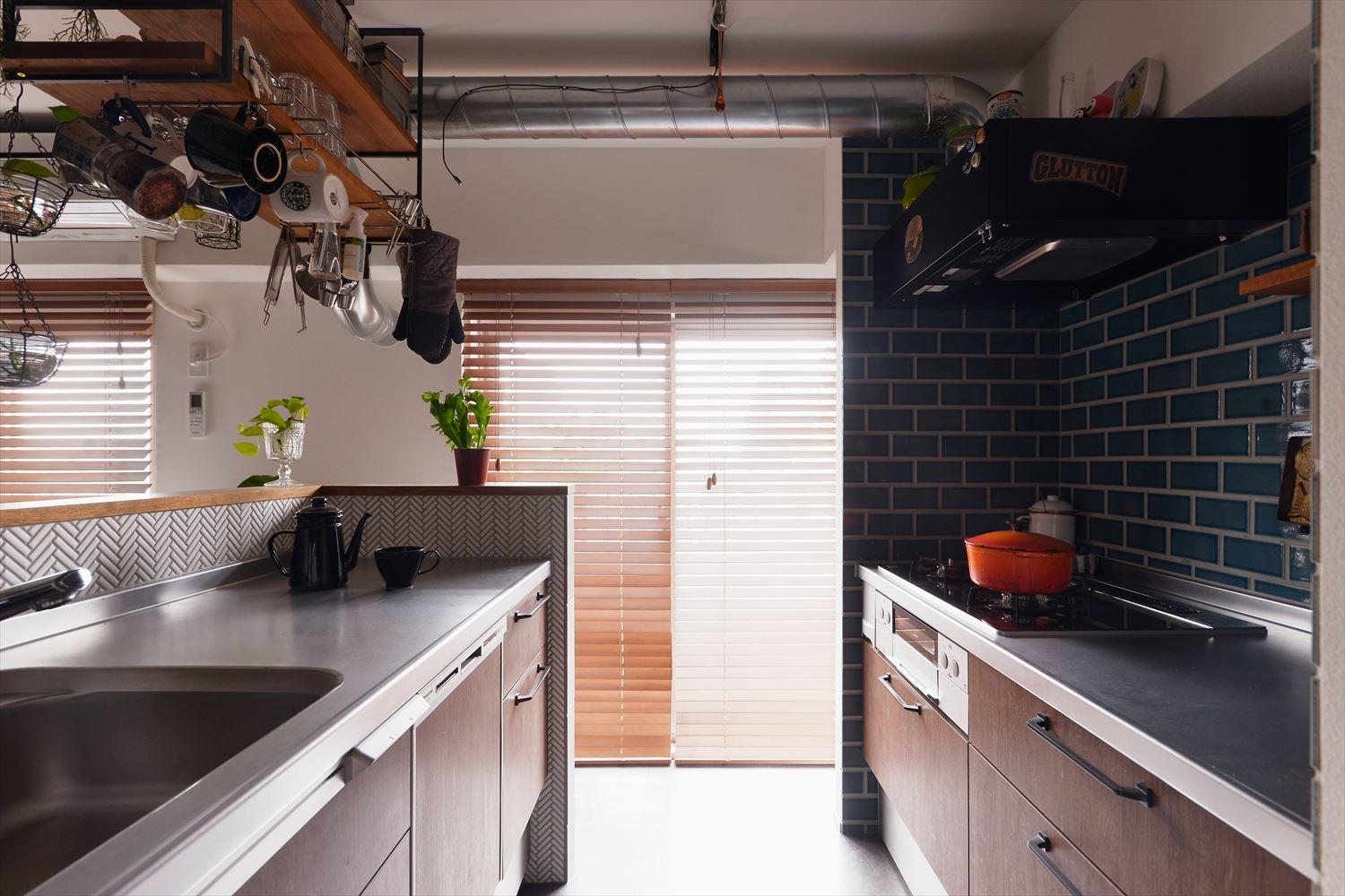 お料理上手なご夫妻がとことんこだわったキッチン。コンロを壁際にシンクを対面にしたⅡ型タイプを採用。シンク側に設置したアイアンの吊り棚にはよく使うもの＆癒やしのグリーンを。