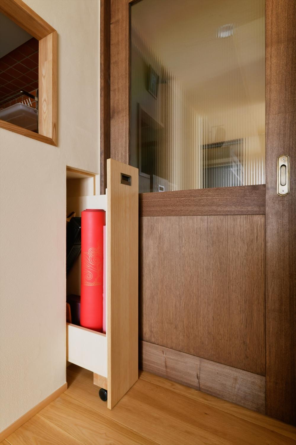 リビングドアの傍に作った秘密の収納。閉じれば壁と一体になってスッキリ隠れる。