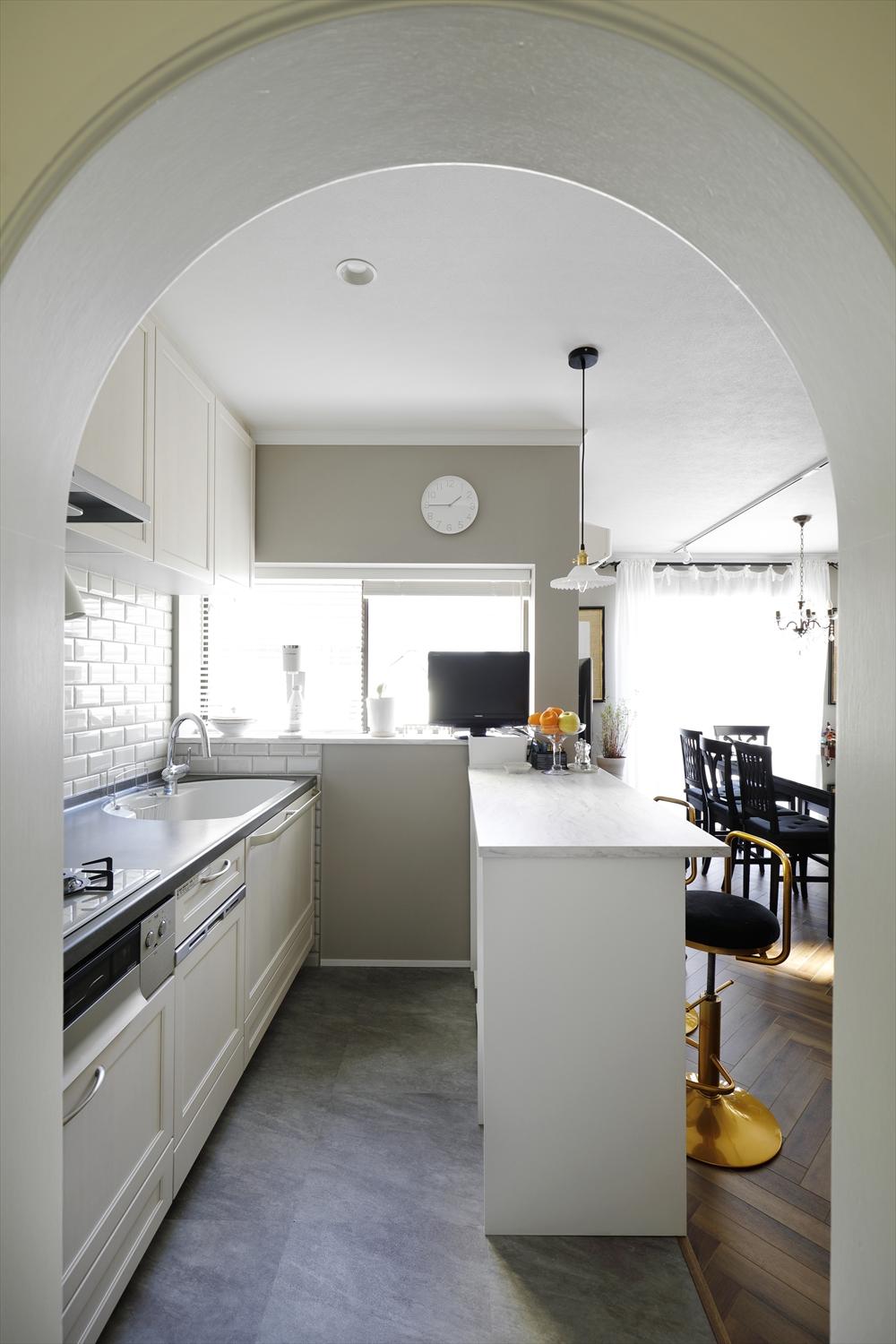 奥まった場所で、大人数の食事の準備をするには使い勝手の悪かったキッチンをダイニング側に移動。窓から緑が望め、明るく爽やかなキッチンに。壁面のタイルもこだわって選んだ。夫のMさんの希望で設置したカウンターは可動式なので、家族が揃うときには取り払ってキッチンを広く使える