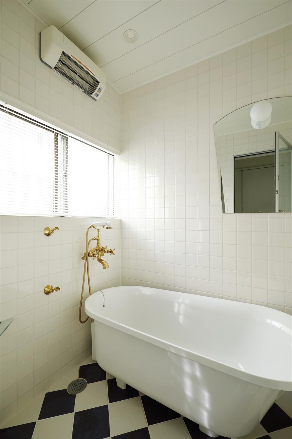 浴槽は以前使っていた猫脚のバスタブの雰囲気を残した置型タイプだが、追い焚きもできる最新設備に交換。お気に入りだった真鍮の水栓やシャワーヘッドは再利用。印象的な市松模様の床もリノベーション前の雰囲気を残した