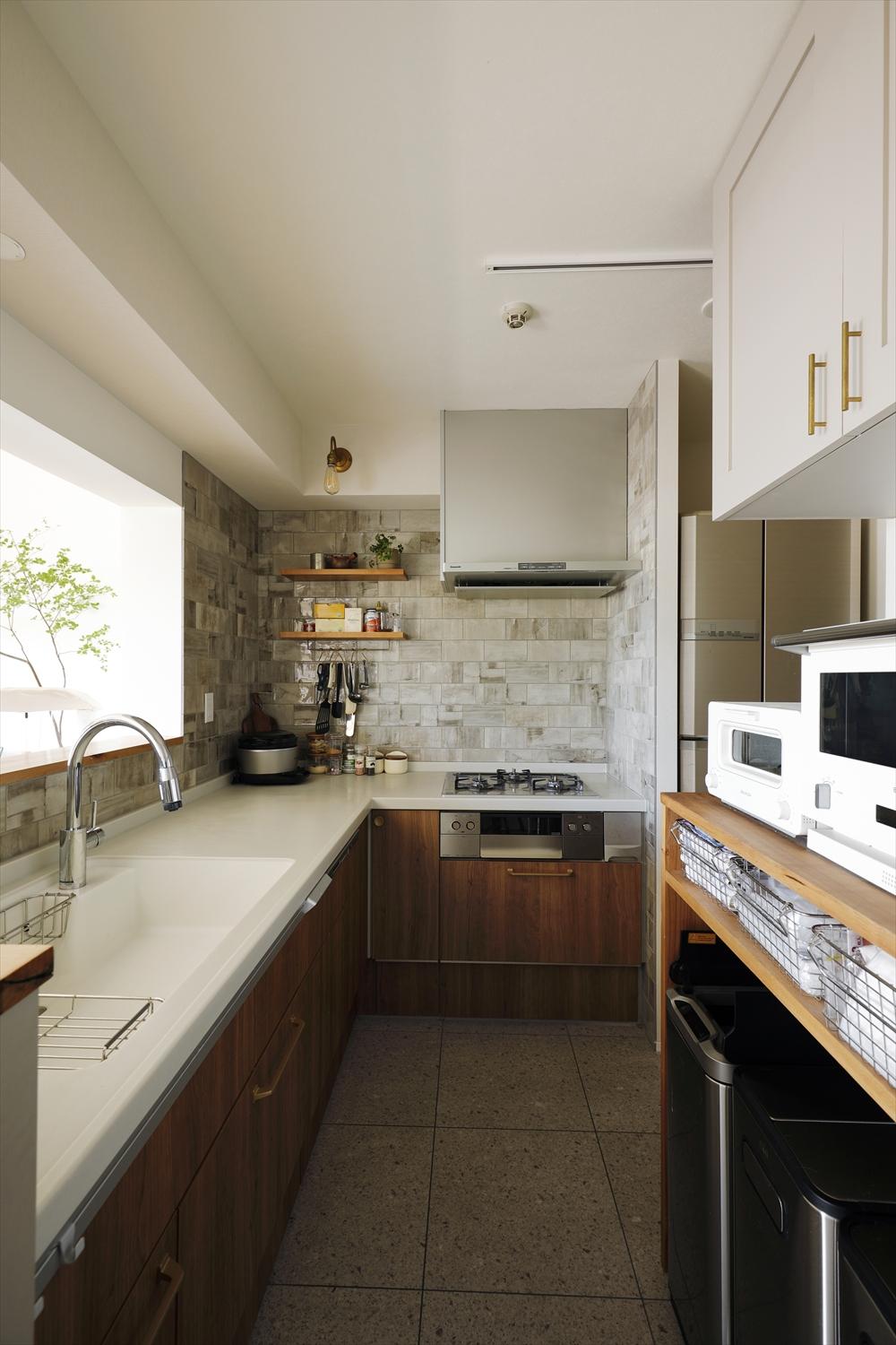 壁づきだったキッチンは配置を変えてダイニングに対面するL型に変更。奥に使ったタイルはショールームで一目惚れしたものだそう。