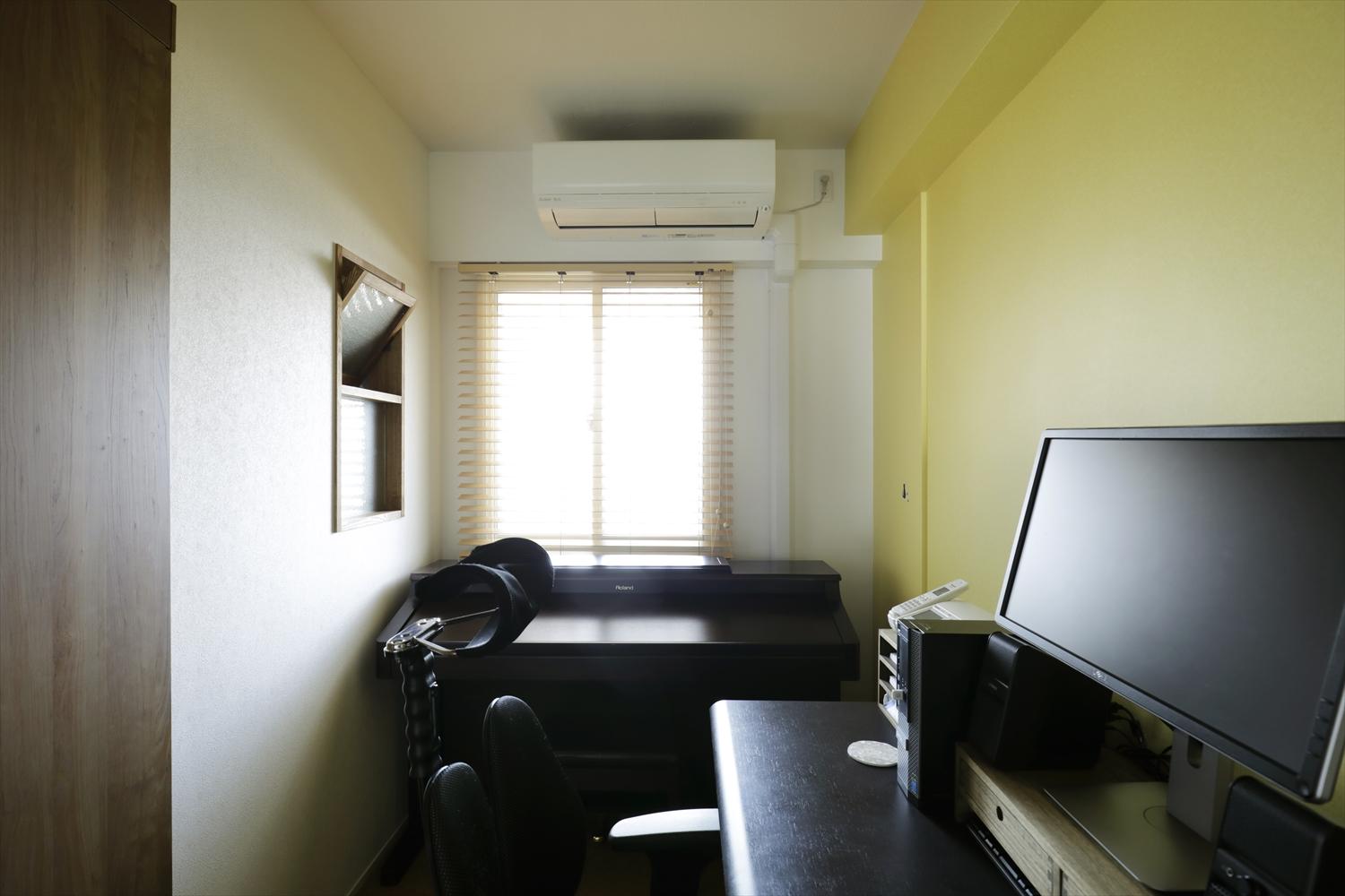 元気の出る黄色のアクセントクロスがポイントの夫の書斎。玄関側に開閉できる室内窓を設置。室内窓をとおして室内の空気が循環される