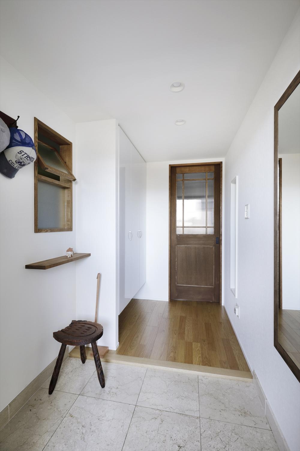 玄関ホール。右手が防音室。左の室内窓の向こうが書斎