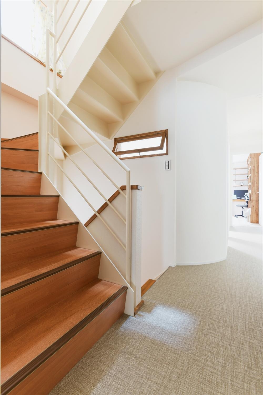 階段で分断されていたフロアを細い路地のような回廊でつなげた。階段室の窓から入る光がカーブを描く壁に反射し、暗くなりがちなフロアの中央も明るく。ハイサイド室内窓を通して、階段室の明るさが北側の個室にも届く