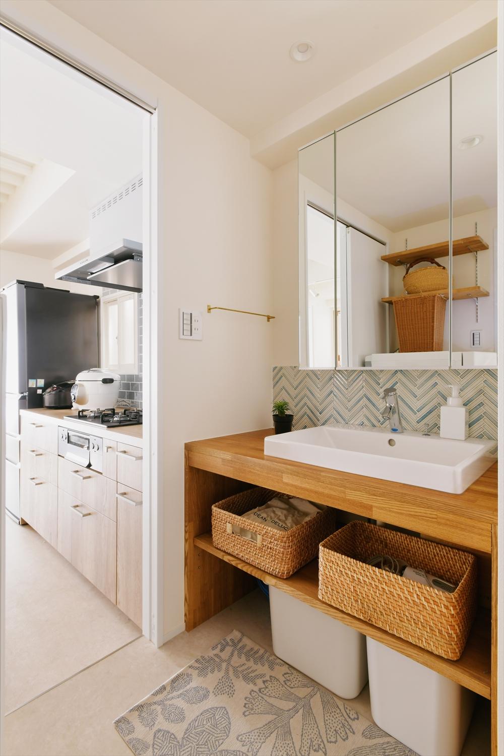 キッチンから直接アクセスできる水回り。回廊側からも入れるので、朝の忙しい時間の動線がスムーズ。キッチンと同系色のタイルで隣り合うキッチンとの統一感を出した