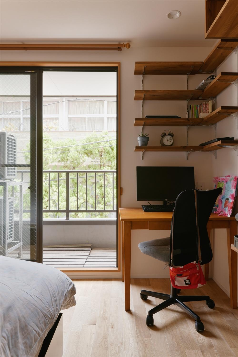 北側の突き当りに位置する主寝室の窓際は、在宅ワークのためのスペースに。杉板を使ったL型の可動棚はナチュラルな木目と風合いを楽しめる