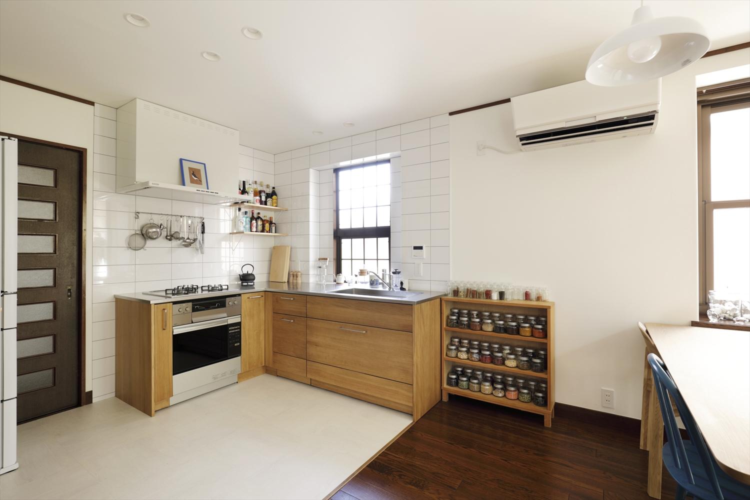 1階のキッチン。位置はそのままだが、無垢の木目が美しいウッドワンのスイージーに交換。以前はキッチンを囲むように収納があったが、取り払ってスッキリとオープンなキッチンに。ダイニングへの配膳もスムーズ