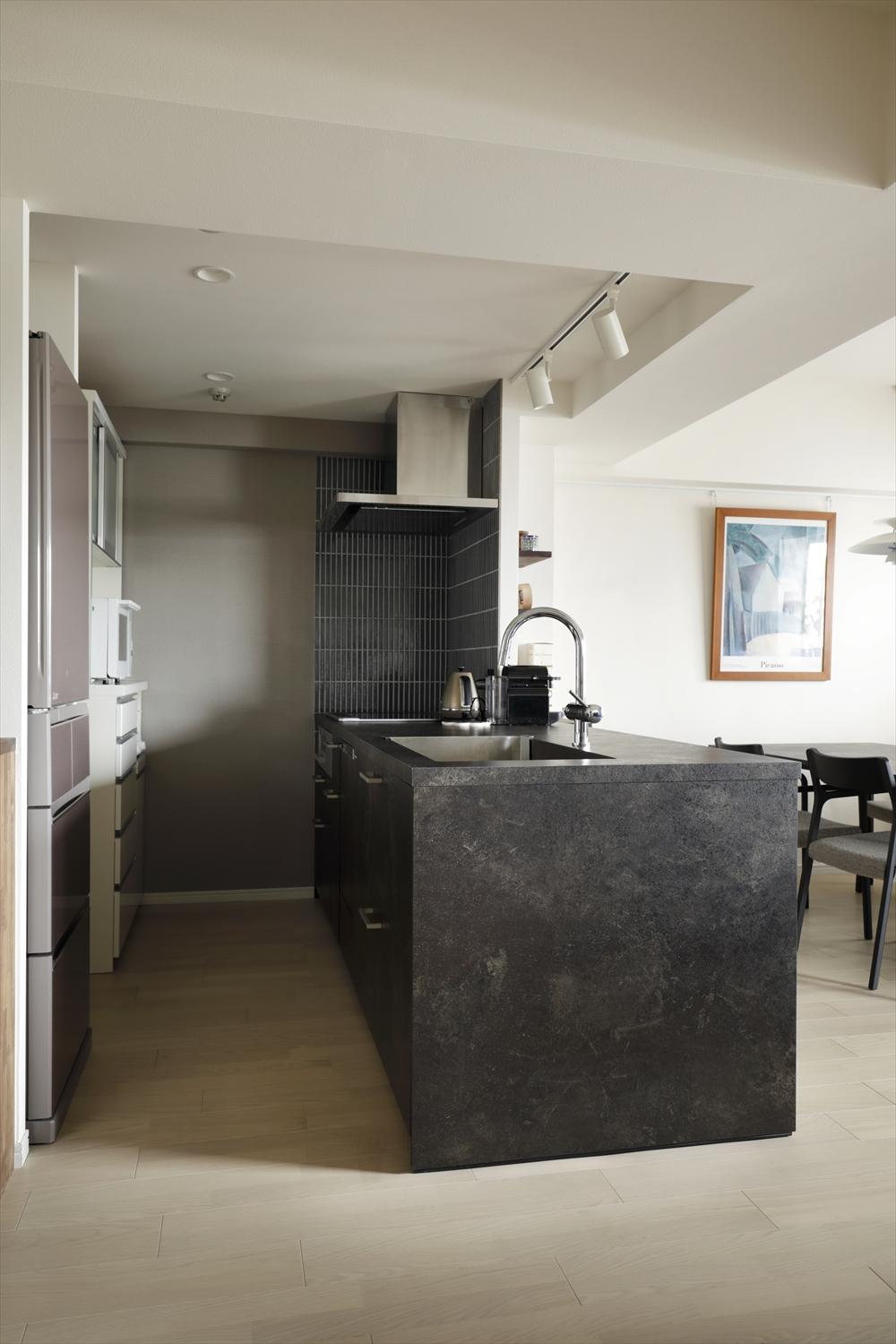 当初からご希望だったグラフテクトのキッチンを採用。キッチン奥の壁は、本体の色味に合わせたグレーのアクセントクロスとブルーグレーのタイルで仕上げた。