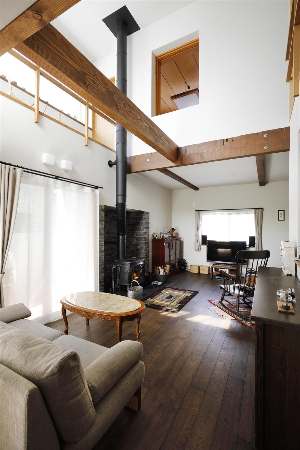 リビングの一角には栃木の家から持ってきた薪ストーブを設置。吹抜けにまっすぐ突き抜ける煙突はご主人のこだわり。構造梁を現し、家具に合わせて塗装したオーク三層フローリングなど、木のぬくもりに溢れている