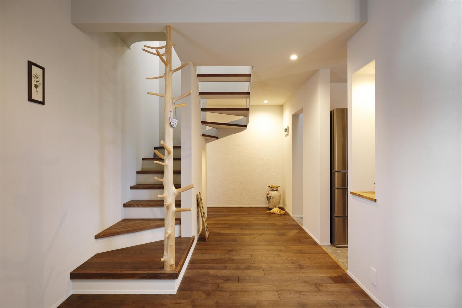 玄関ホールから直接パントリー・水廻りに続くバックヤードへ、キッチンへ、リビングへ、そして階段で2階にも上がれる4つの動線を計画。階段の上り口にあしらった変木（枝を残した材）は「いつまでも元気に階段を上り下りできるように」という願いを込めて