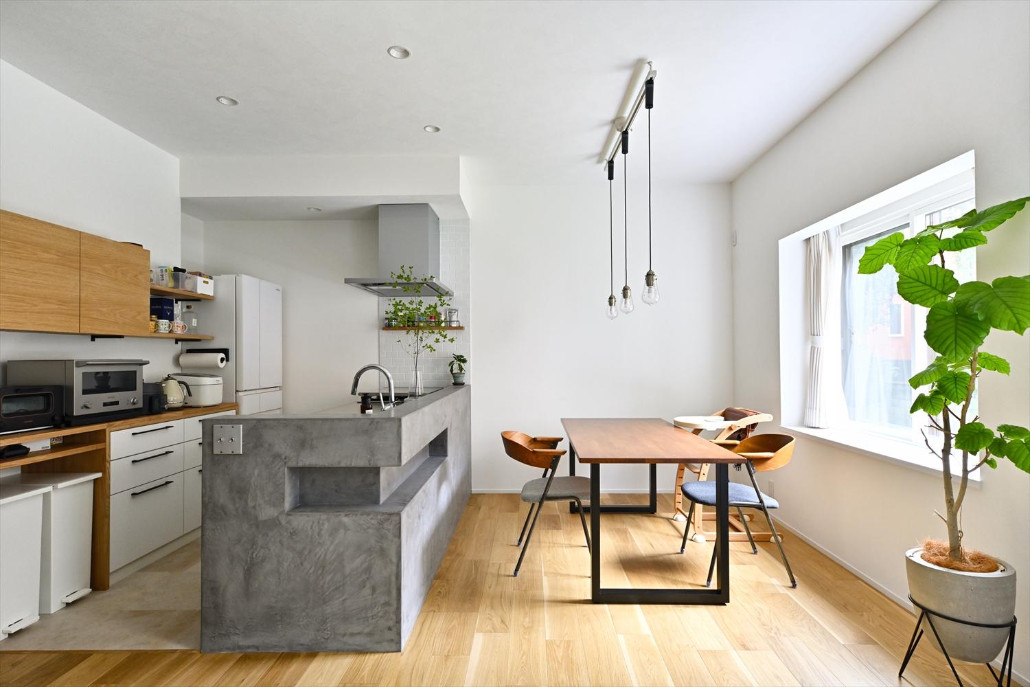 白いクロスと明るい木目のナチュラル空間で、モールテックス仕上げのキッチンカウンターがアクセントに。カフェのような、キッチン・ダイニング