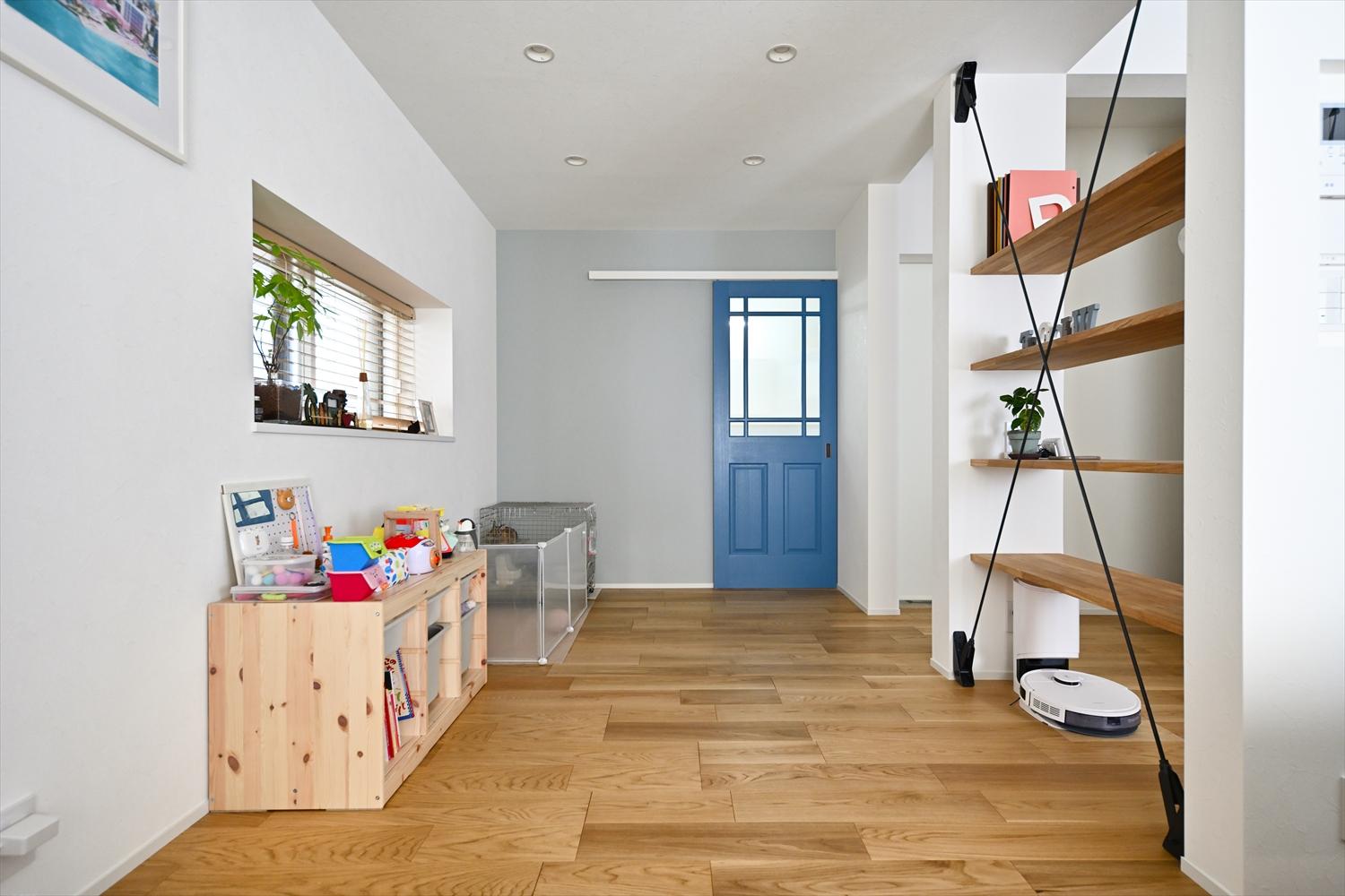 もともとキッチンのあった場所はリビングとつながるお子さんのプレイスペースに。奥の青い引き戸の向こうはランドリースペース