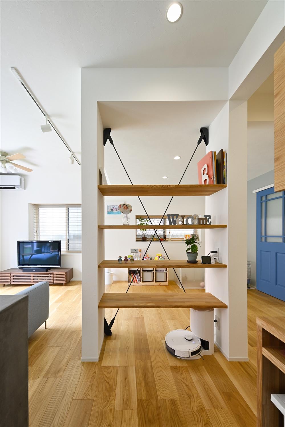 構造上残した柱と筋交いの間に板を渡して飾り棚を作った。キッチンからは棚越しにお子さんのプレイスペースを見守れる