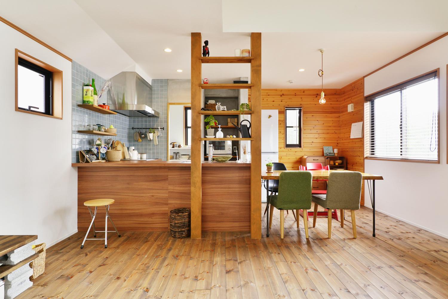 キッチンの向きをリビング側に向くように変えて、より広々としたLDKに。リビング奥（ダイニング）の板張りの壁は既存を再利用