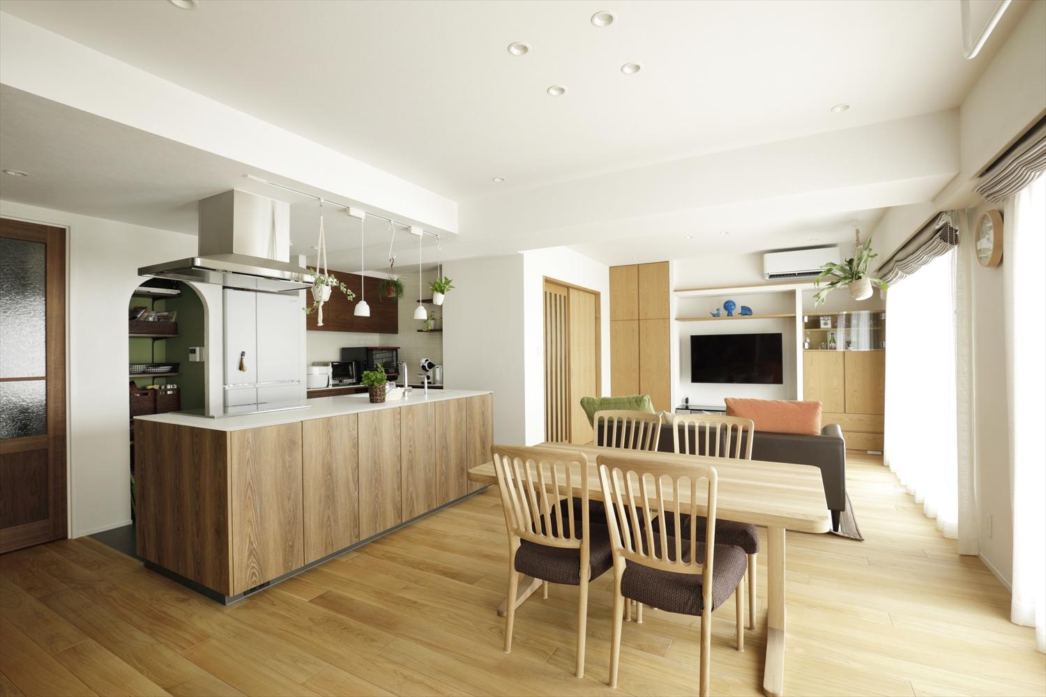 キッチンの側面や造作家具の面材をフローリングの色と合わせて統一感のあるLDK。一面が造作収納になっていたテレビ側の壁は一部をオープンに。圧迫感が減りより広さを感じられるように。