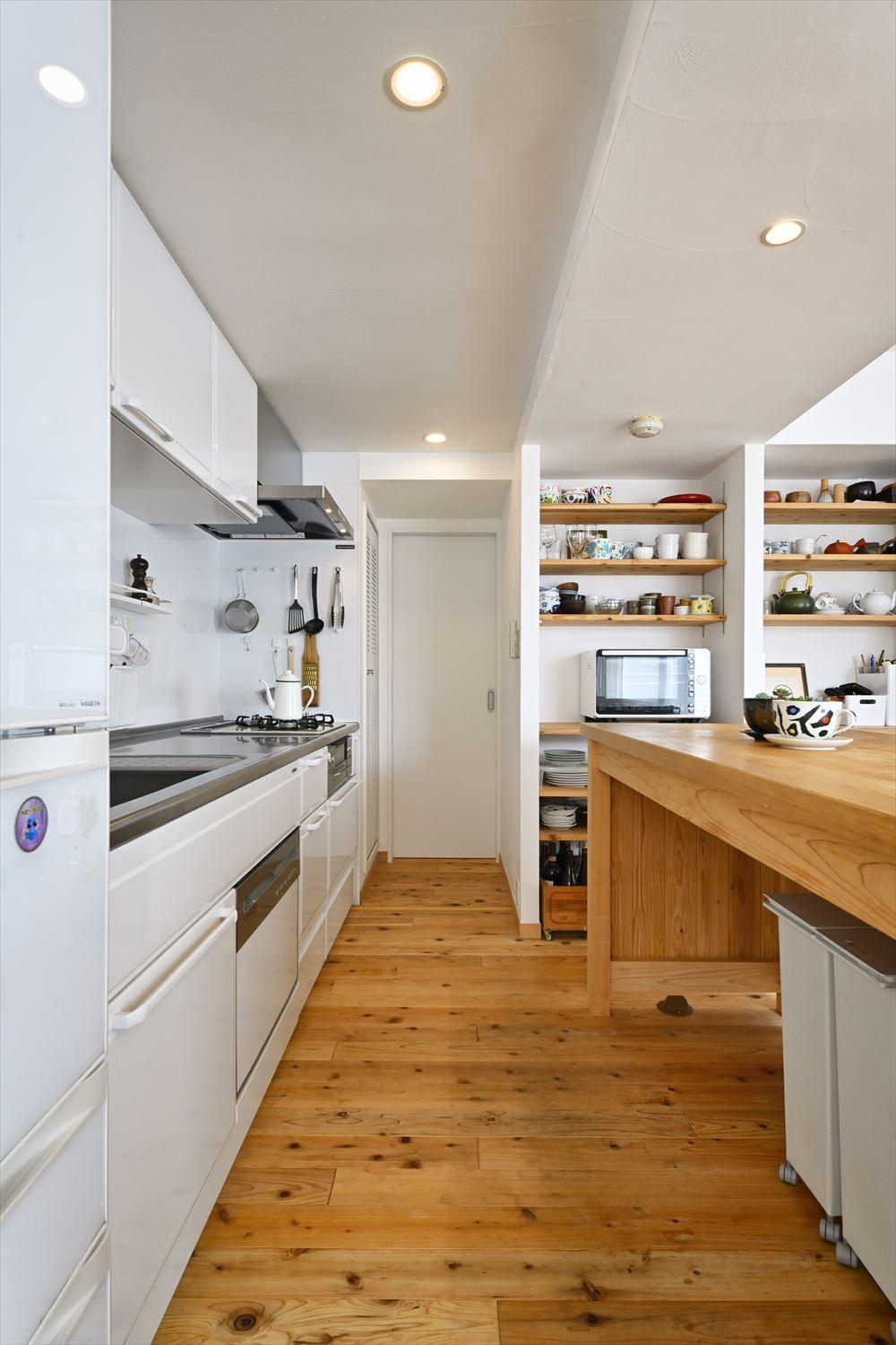 以前のお住まいでも使い勝手の良さを感じていた壁付けキッチンを今回も採用。周囲を囲っていた壁は取り払い、背面にお手持ちのカウンターを設置。食器や家電を置けるオープン収納も造作し、より使い勝手の良いキッチンに。