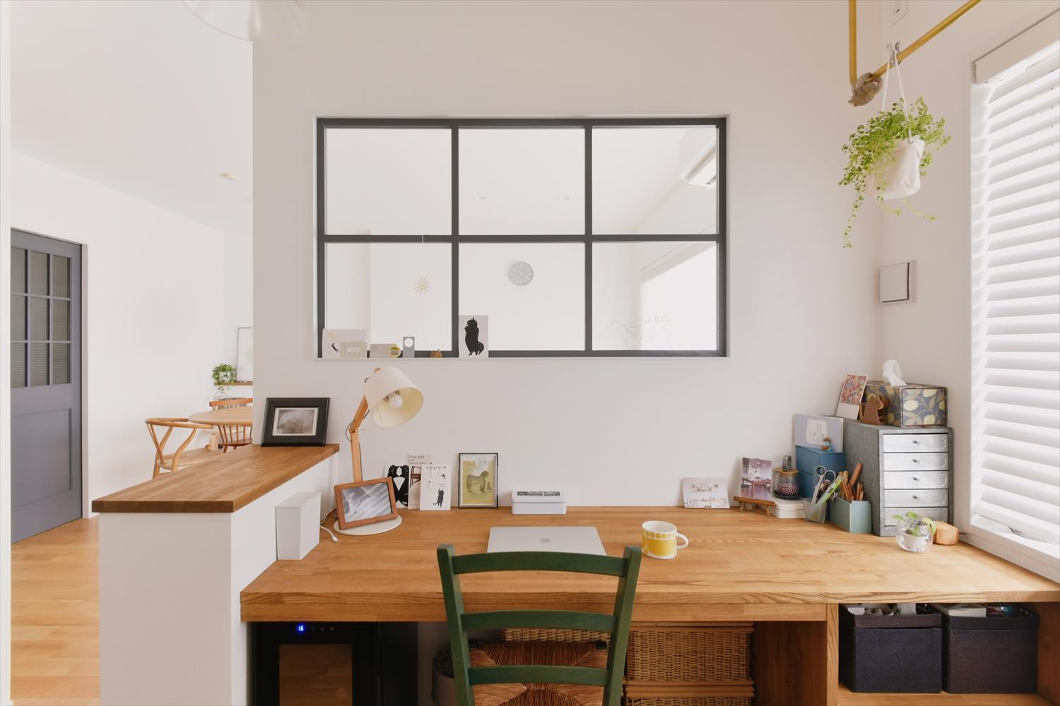 リビング隣の妻のワークスペース。リビングに面する壁には大きな室内窓を。2面から光が入り、明るく開放感も感じられる一方で、程よい籠もり感で集中して作業もできる。
