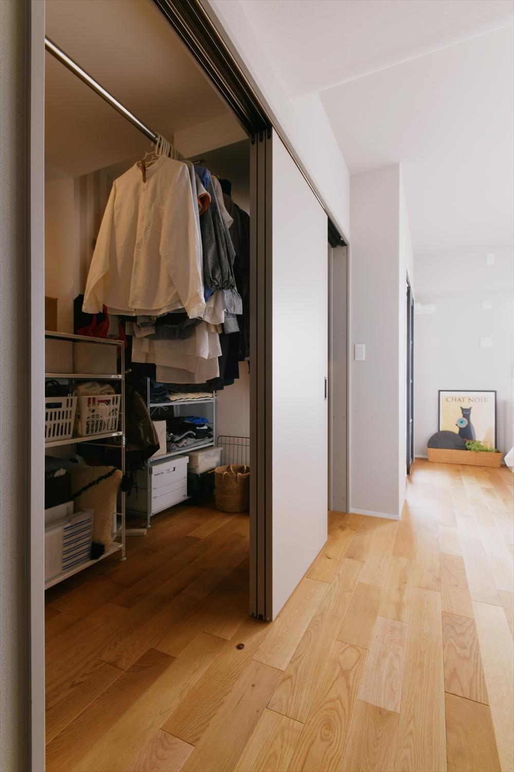 寝室から玄関に抜ける動線上にウォークインクローゼットを配置。収納量もたっぷり。3枚引き戸で大きく開くので使い勝手も良い。正面には別の収納もつくったので、細々したものもスッキリ片付く。