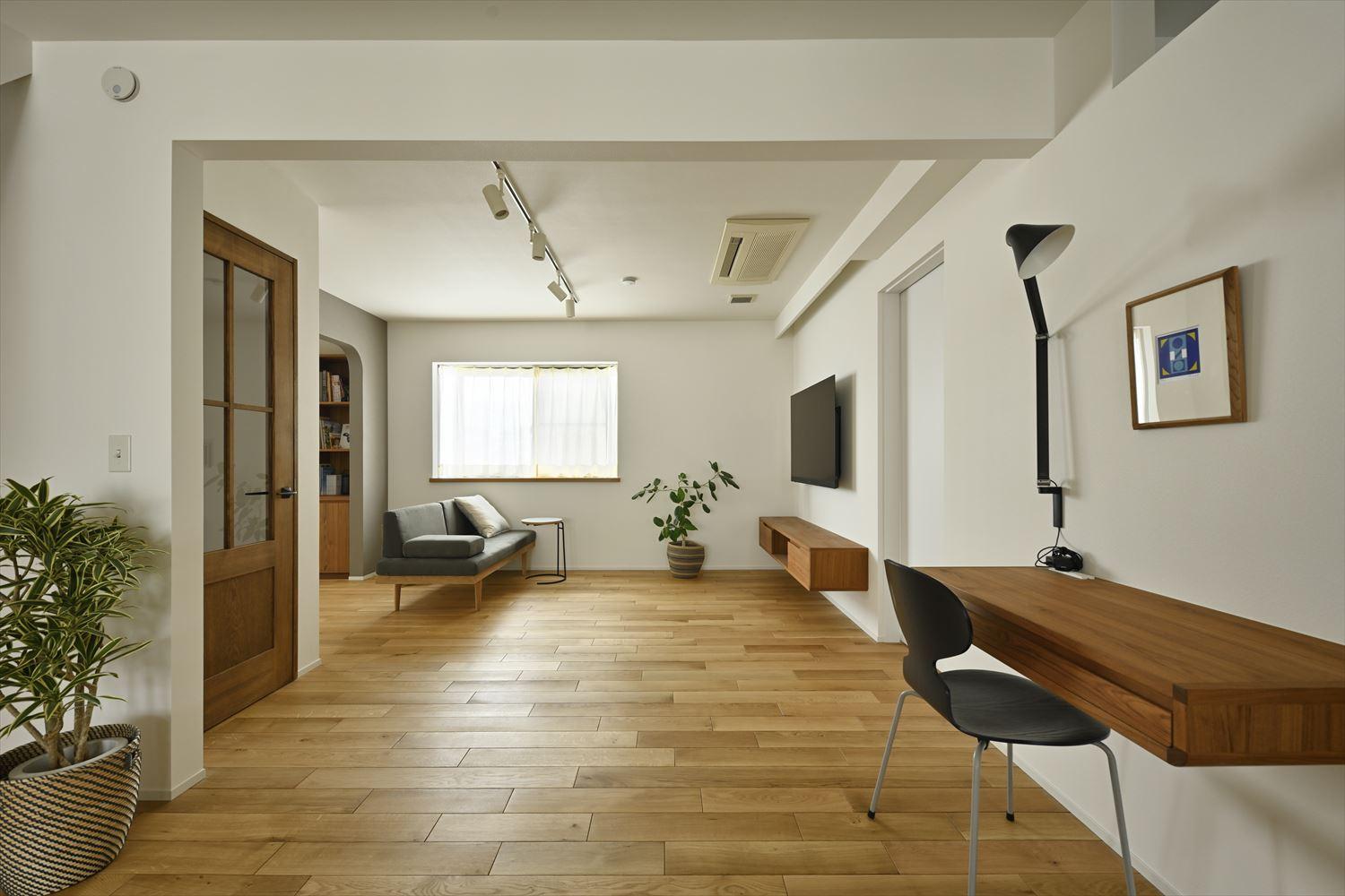 収納家具やPCカウンターはチーク材を使ってオーダー。デザインテイストを揃えた統一感が白をベースにつくったシンプルな空間のアクセントに。飽きのこない大人の空間に仕上げた