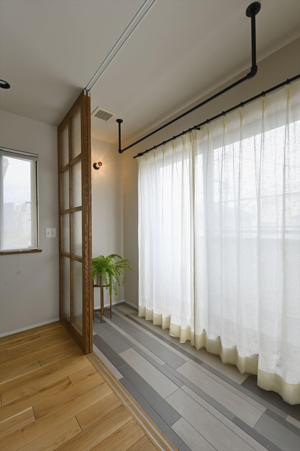 インナーテラスとライブラリーはガラス入りの造作建具で仕切った。外からの視線を遮りながらたっぷりの陽光を室内へ届けてくれる