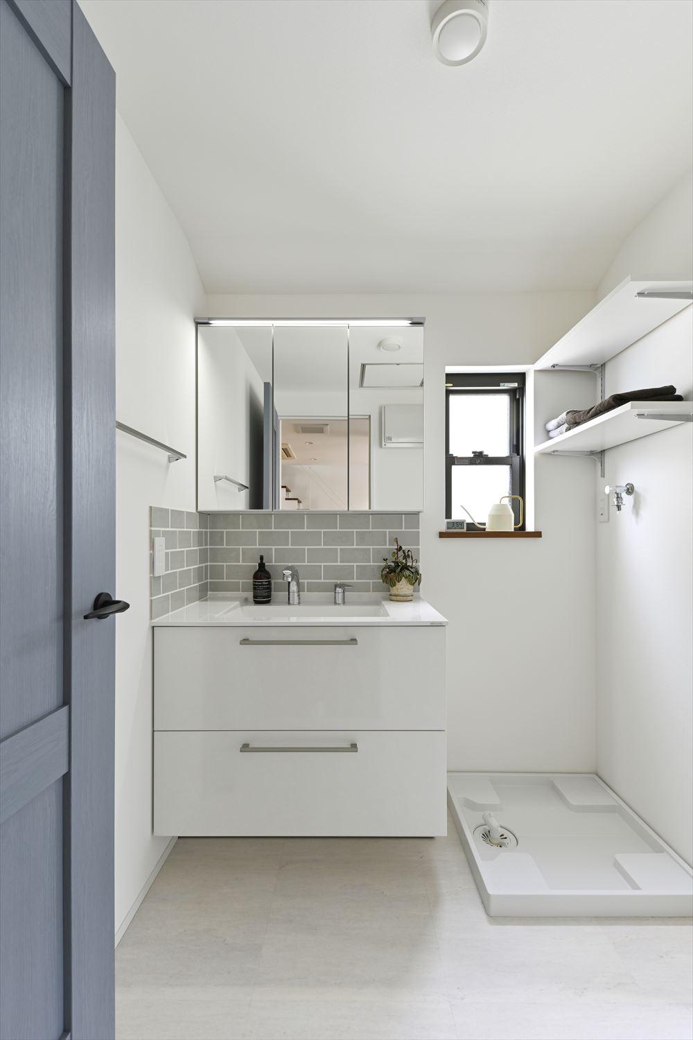 洗面の立ち上がりはキッチンの壁に使ったタイルの色違いで仕上げた