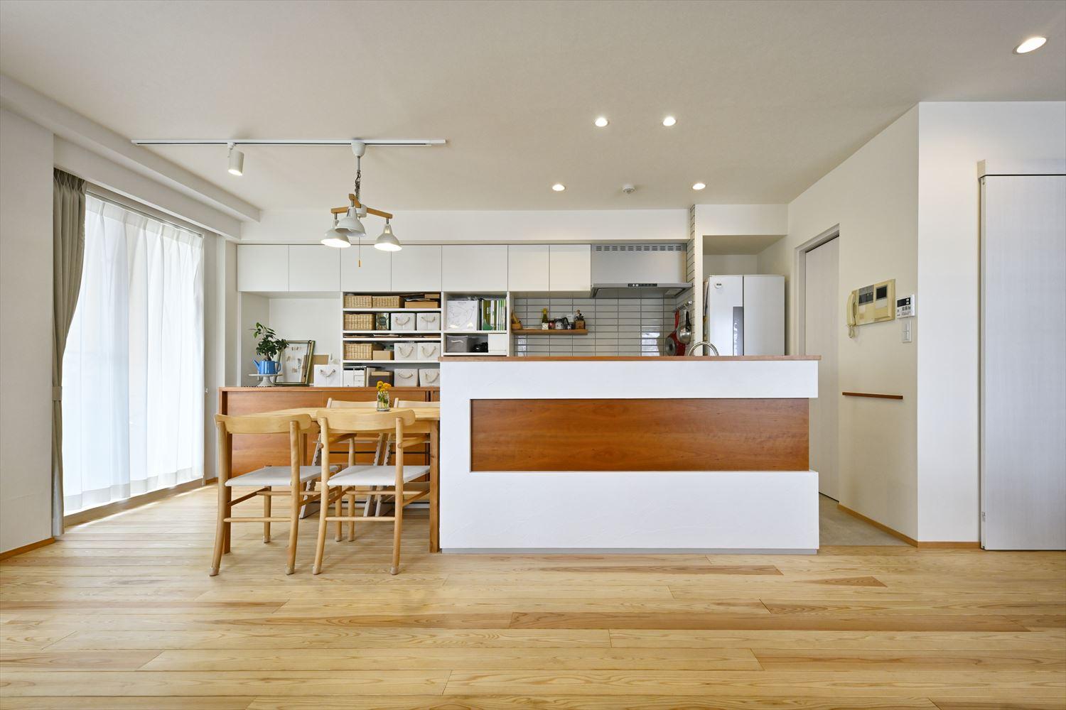 国産の天竜杉をフローリングとして使用。心地よい香りと柔らかい足ざわりを楽しめる。キッチンカウンターにはサクラの無垢材をあしらった