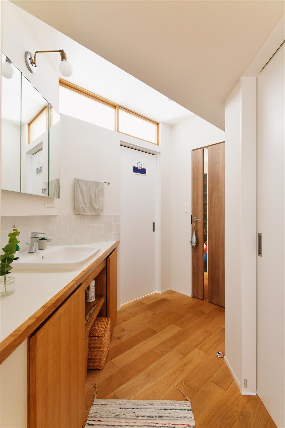 玄関ホールを抜けたスペースに、洗面台を斜めに配置。室内窓を設け、光も風にも配慮。壁には珪藻土を使用し、調湿・消臭にも効果的。