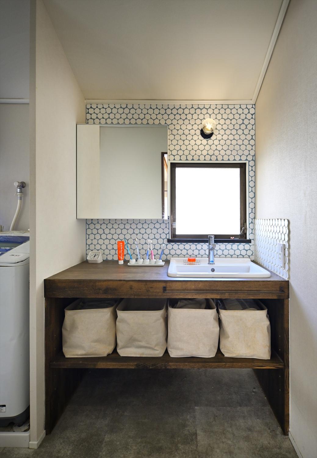 ゆったりとした洗面スペース。下をオープンにした造作洗面台は、収納するものに合わせた収納ケースですっきり。