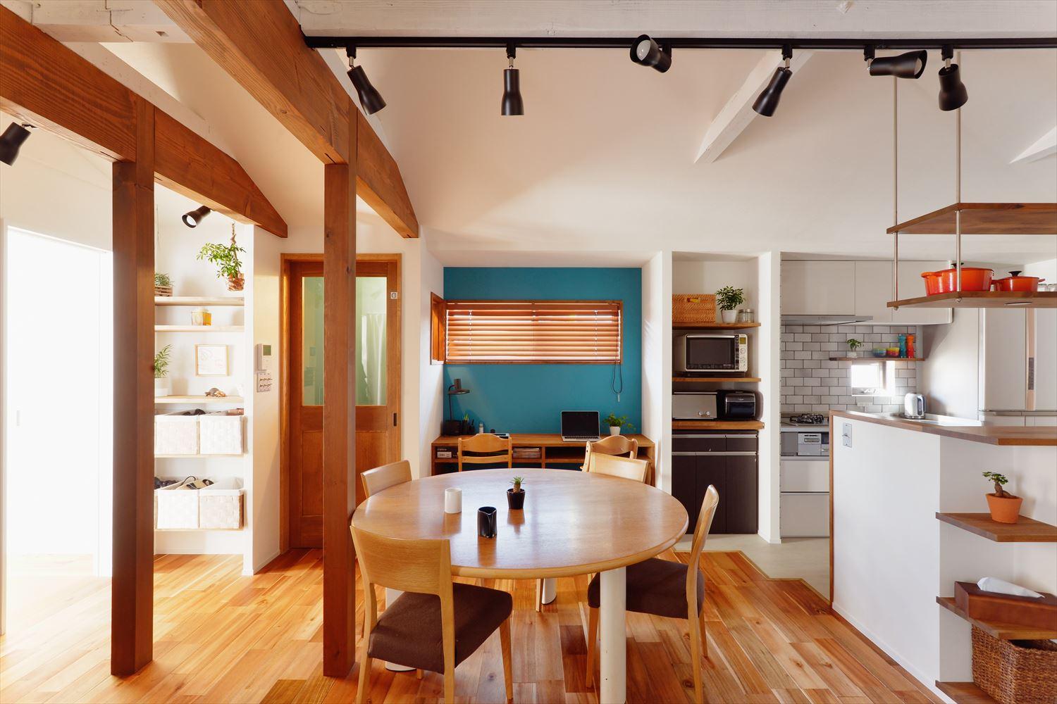 子世帯のLDK。直径160cmの大きなテーブルを中心に配置。梁を現しにして高さを出し、コンパクトながら開放感を感じられるように