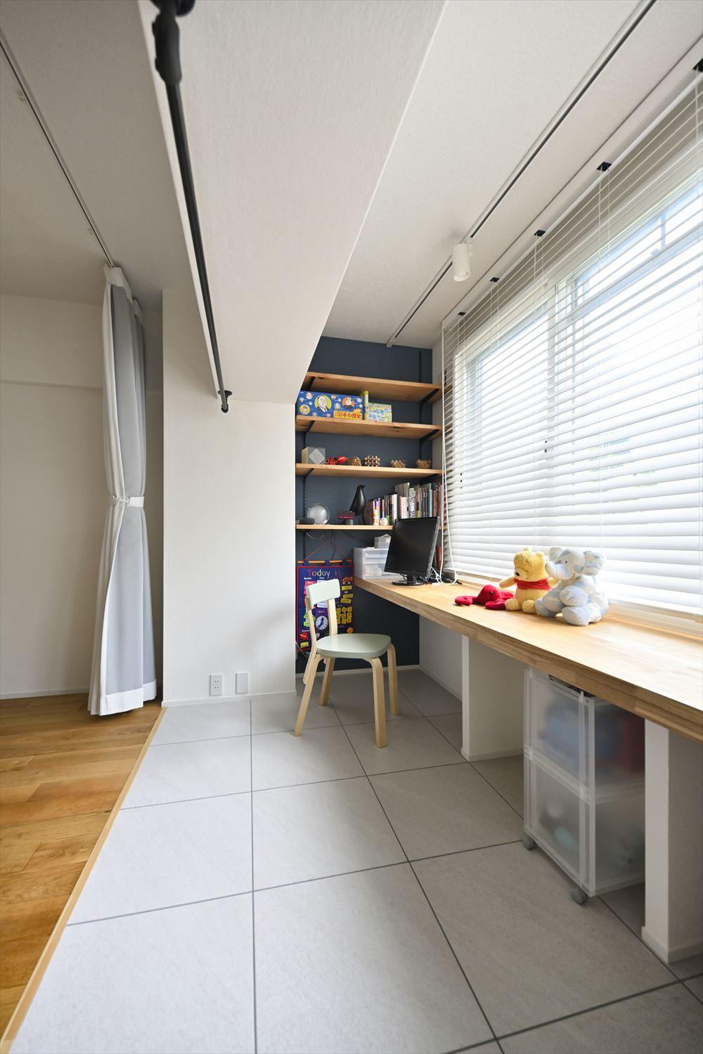 明るい窓際にはカウンターデスクを設置。子ども室の間仕切りをスタディスペースの手前までにすることで、リビングからも子ども室からもアクセスできるようにしている。子ども室を個室として使いたいときはカーテンで間仕切りできる