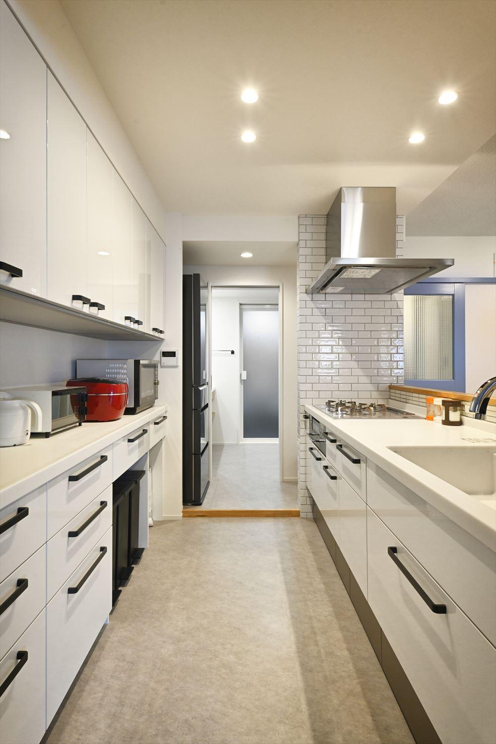 対面式のキッチンにもバルコニーからの光が届き、明るい。キッチンからは直接奥の水回りにアクセス出来るようにして、家事の効率化を