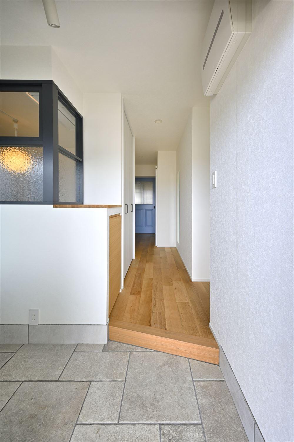 玄関横の居室の一部を玄関土間に取り込んだので、共用廊下側からの光が玄関や廊下に届き、家中が明るく。窓のない寝室には室内窓を設け、そちらにも光が届くようにした
