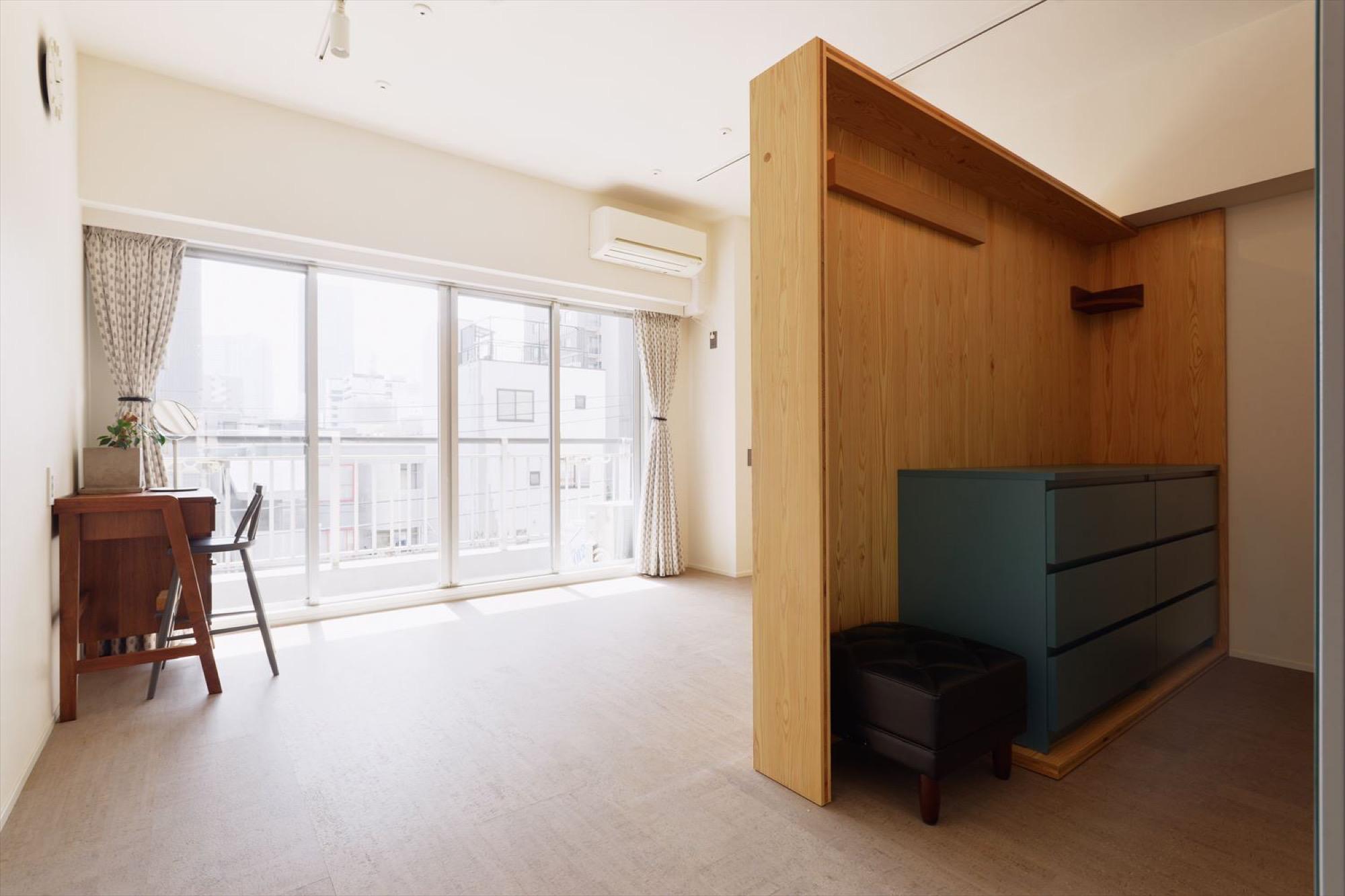 広い寝室には可動式の壁を設置して、暮らしに合わせて間仕切りを変えられるように。床は足ざわりの良いコルクタイルを採用。