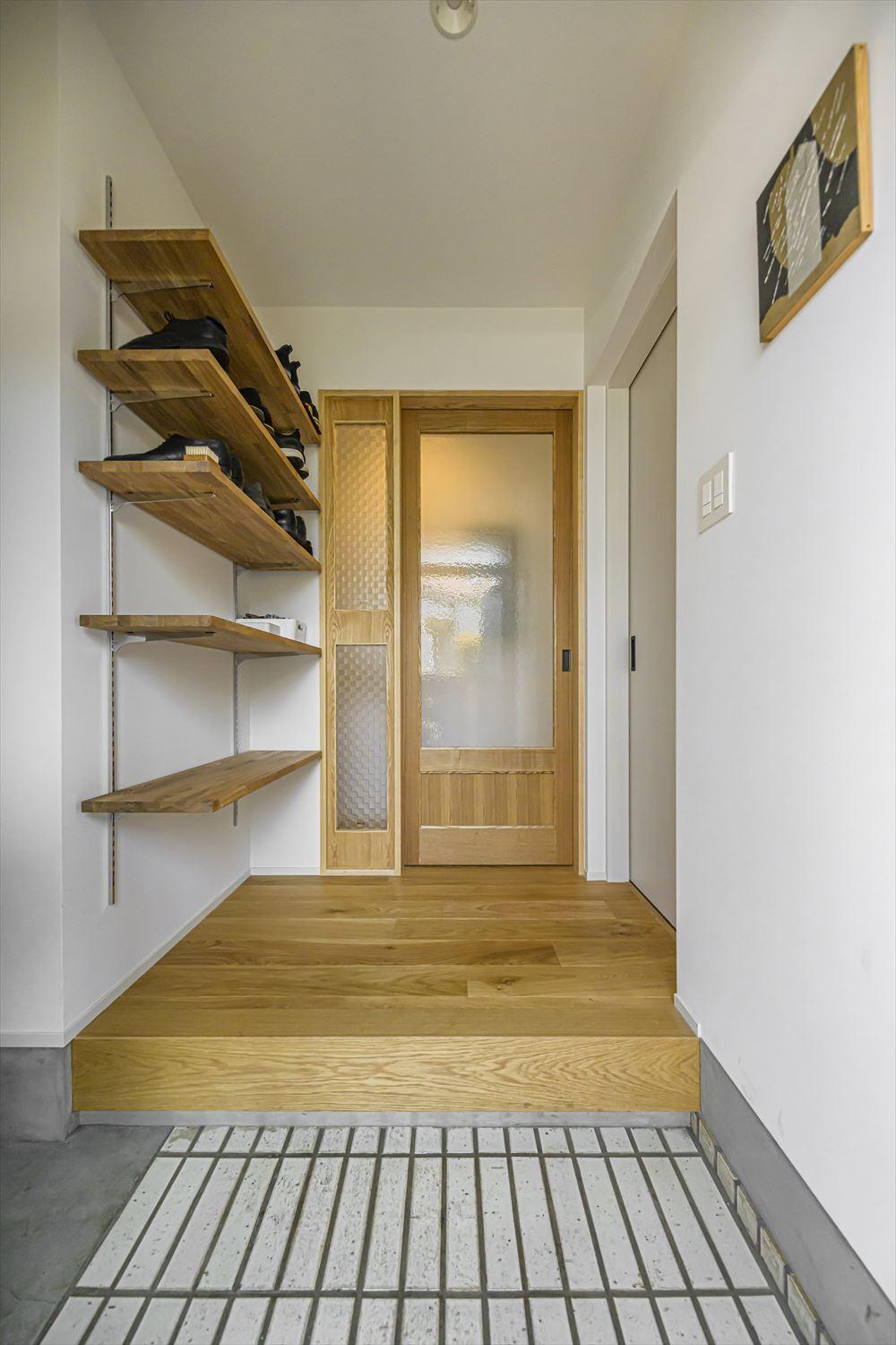 玄関に敷いたタイルや建具横に設けたスリット窓のガラスはおじいさまのお住まいから取り出し、再利用したもの