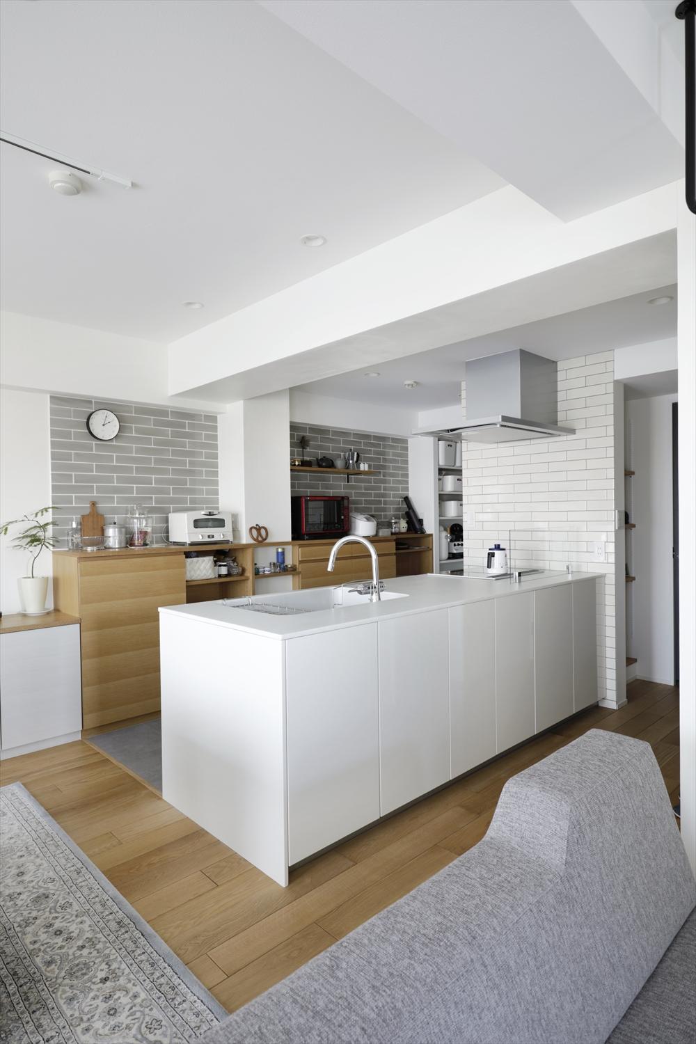 向きを変えてフルフラットのペニンシュラ型を採用したキッチン。仕切り壁や下り壁がなくなり、リビング・ダイニングとつながる空間に。パントリーやキッチン背面の造作収納で、キッチン周りはいつでもすっきり。