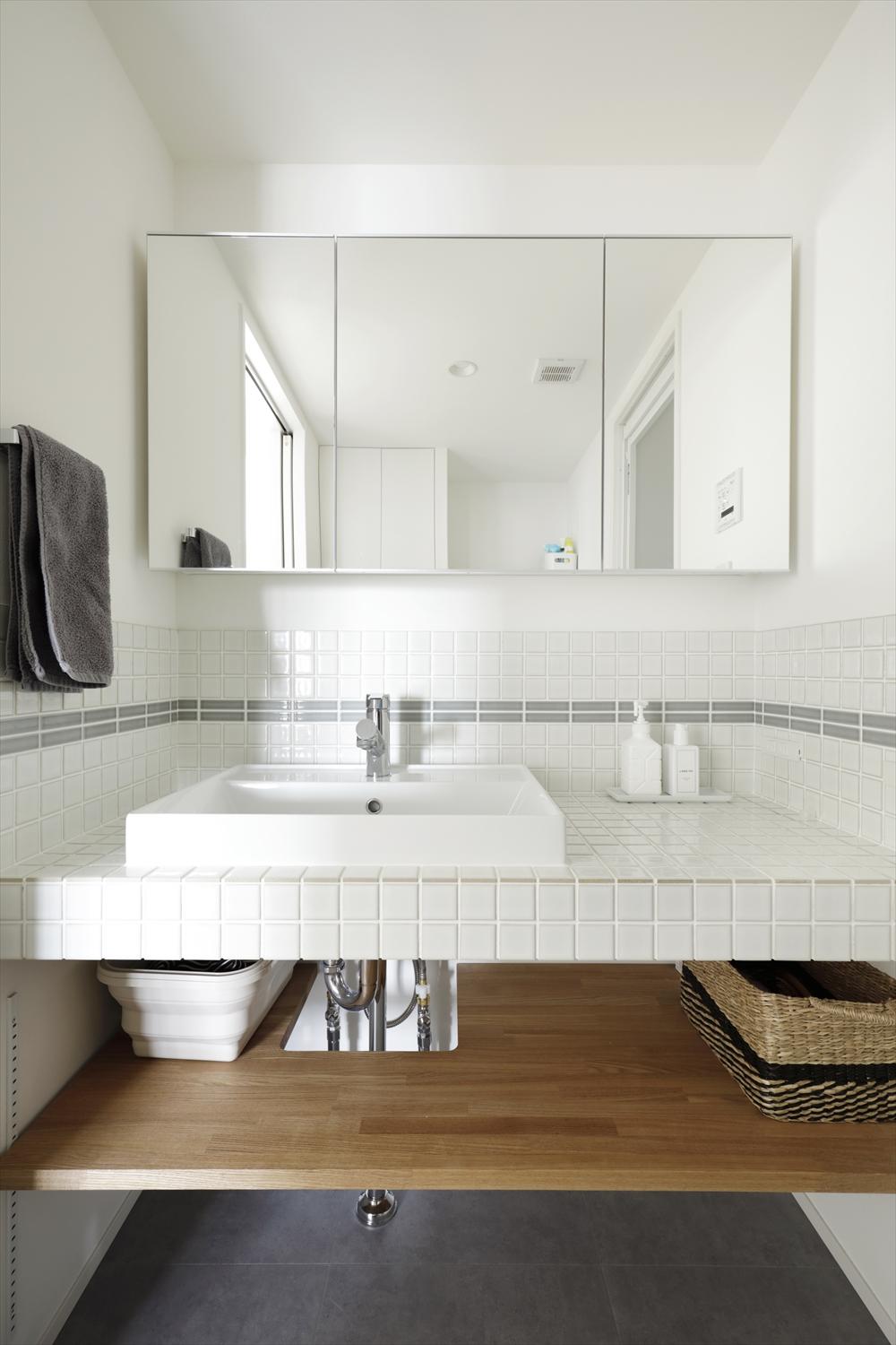 洗面室を広げて作業スペースも確保した洗面台は造作で。愛犬のお散歩後には、ここで足を洗えるように、天板はタイル貼りで仕上げた。