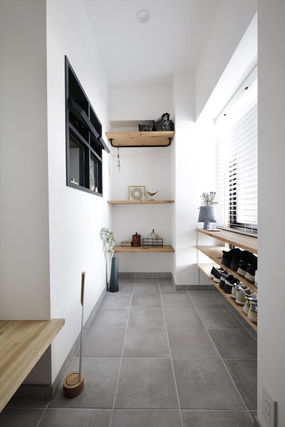 居室の一部を取り込んで広げた玄関土間。普段使いの靴はOPEN棚に置けるので、使い勝手も◎奥にはコート掛けも用意。